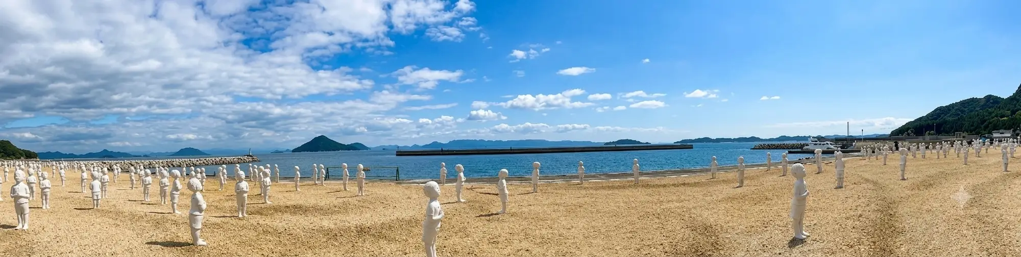 Beyond the Border - Prayer, an art installation by Lin Shuen Long on Teshima Island, Japan: statues of children in a praying position, one for each country, arranged along a beach